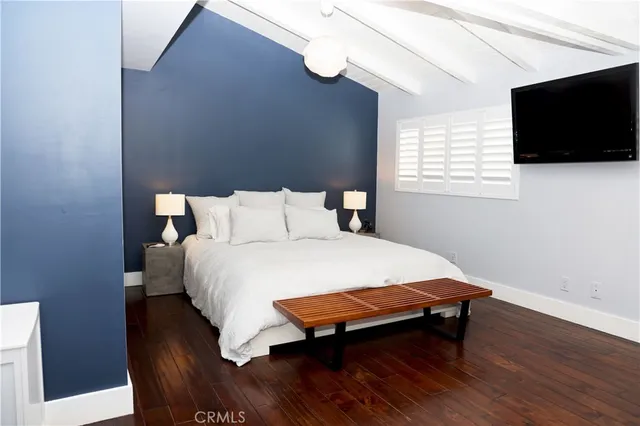 a bed sitting in a bedroom and tv