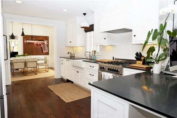 a open kitchen with stainless steel appliances granite countertop a sink a stove counter space and cabinets