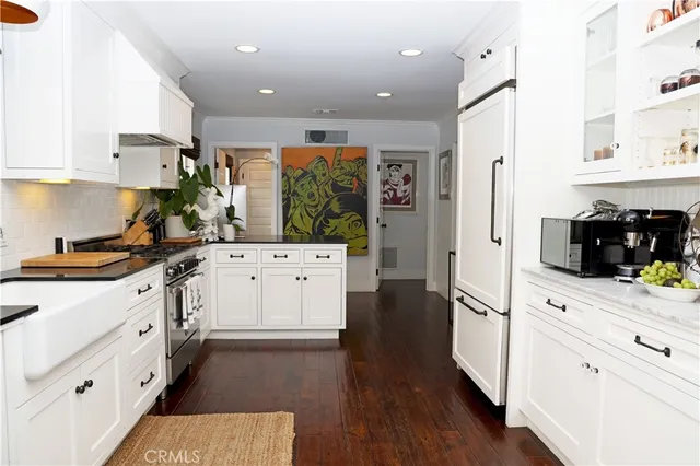 a kitchen with white cabinets and appliances