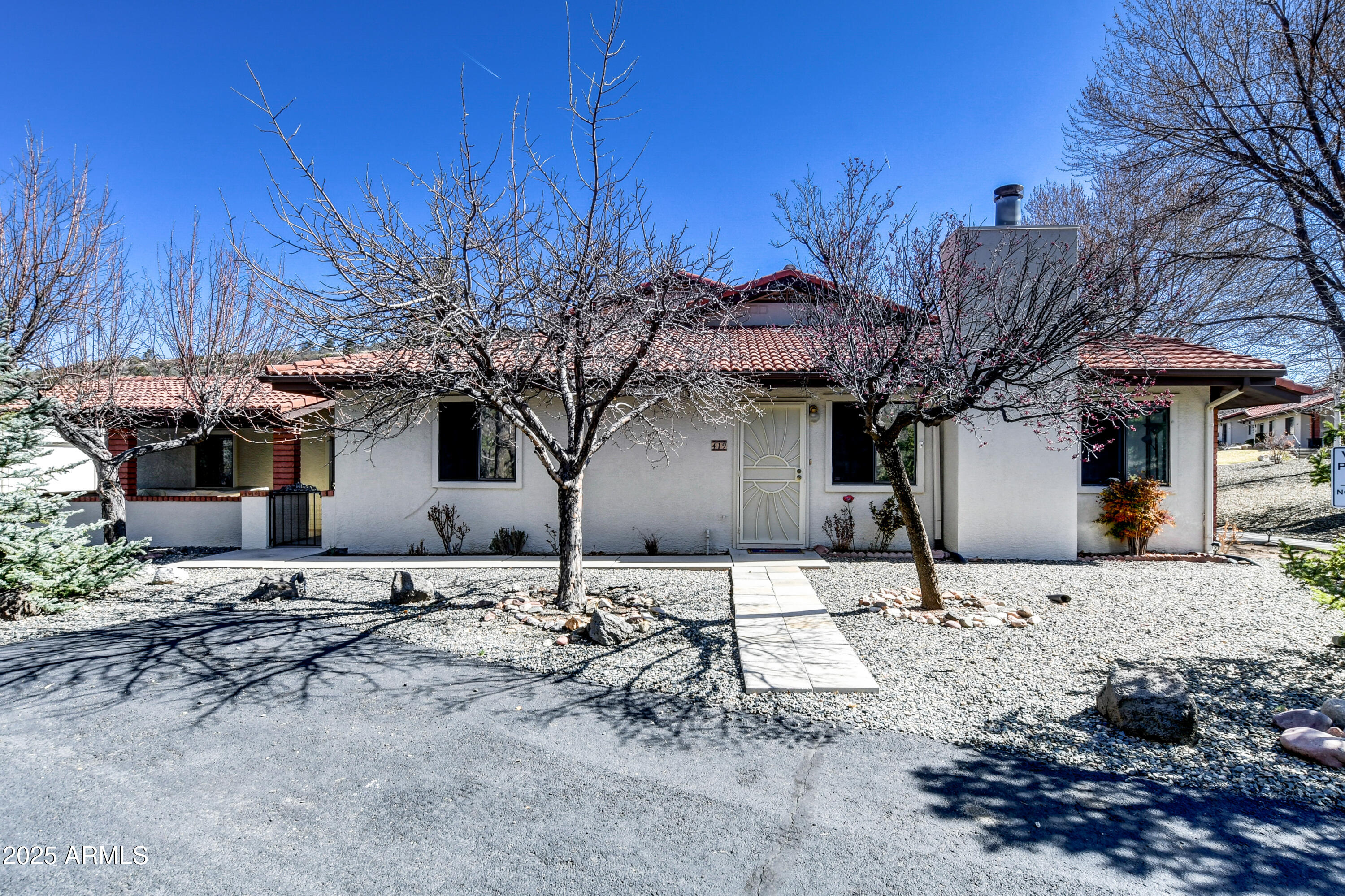 a front view of a house with a yard covered with snow