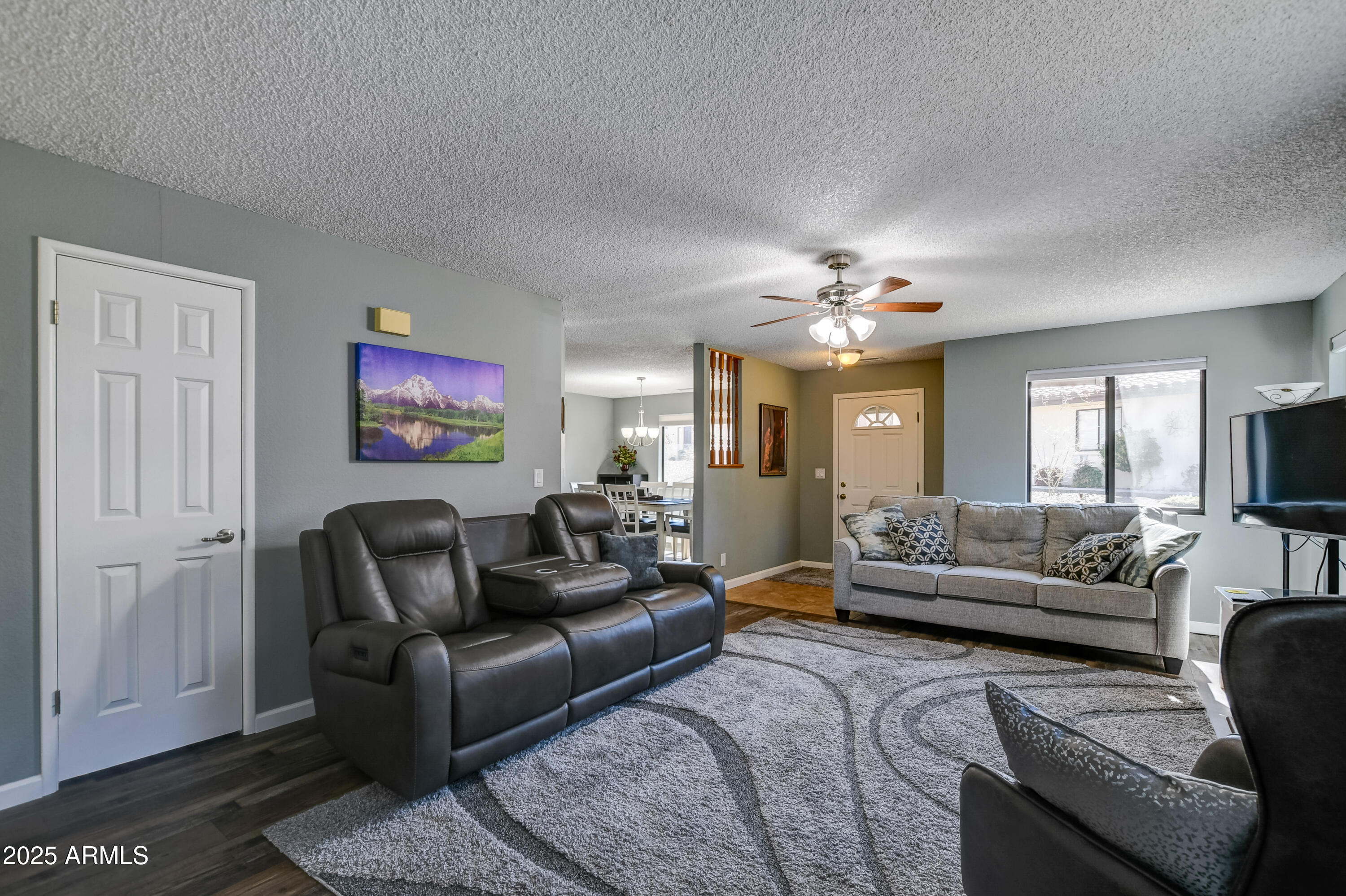 419 Apache Plume Trail Prescott, AZ 86301 - Photo 2 of 21 a living room with furniture a chandelier and a flat screen tv