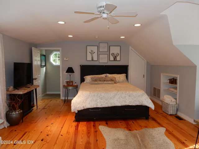 a bed room with a bed a television and a large window