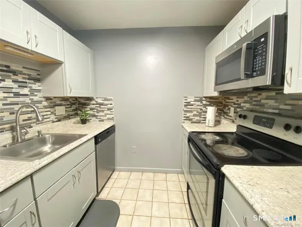 a kitchen with stainless steel appliances granite countertop a sink stove and cabinets