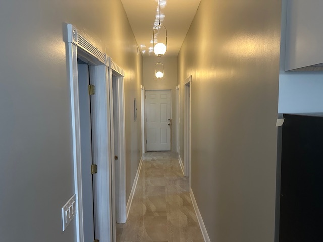 5743 South Emerald Avenue Chicago, IL 60621 - Photo 11 of 28 a view of a hallway with wooden floor