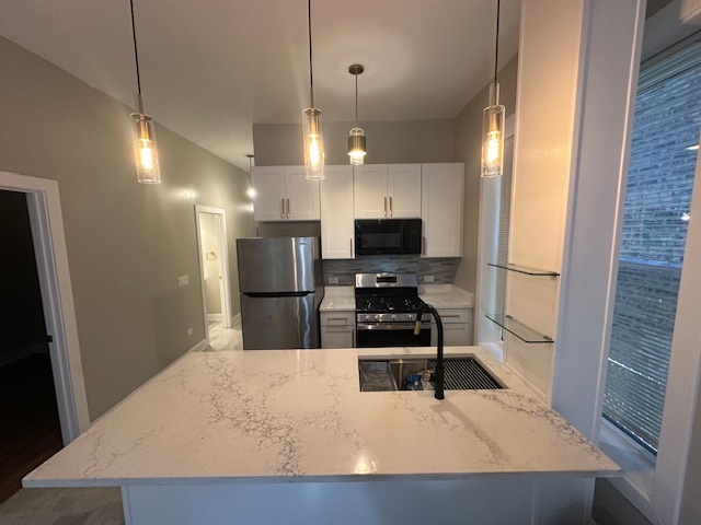 5743 South Emerald Avenue Chicago, IL 60621 - Photo 19 of 28 a kitchen with stainless steel appliances kitchen island granite countertop a refrigerator a stove top oven a sink and dishwasher