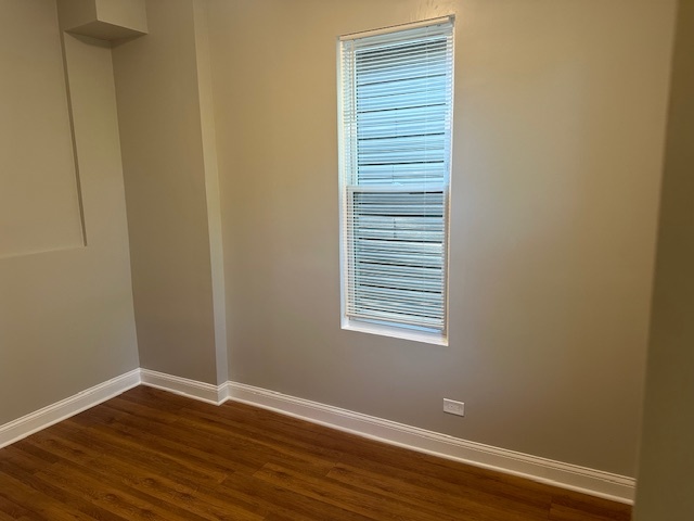 5743 South Emerald Avenue Chicago, IL 60621 - Photo 8 of 28 a view of an empty room with wooden floor and a window