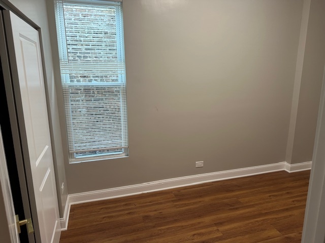 5743 South Emerald Avenue Chicago, IL 60621 - Photo 10 of 28 a view of an empty room with wooden floor and a window