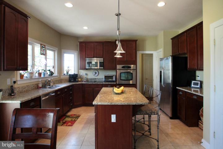 19505 Middletown Road Freeland, MD 21053 - Photo 3 of 30 a kitchen with stainless steel appliances granite countertop a sink refrigerator and cabinets