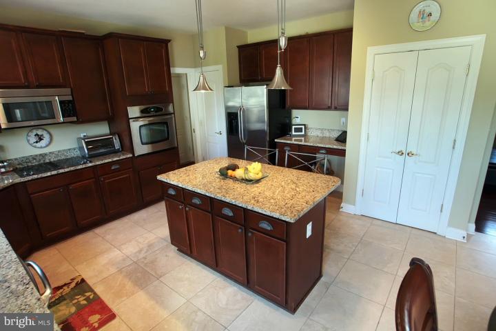 19505 Middletown Road Freeland, MD 21053 - Photo 4 of 30 a kitchen with stainless steel appliances granite countertop a stove refrigerator and wooden cabinets