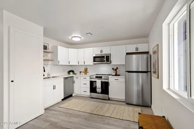 a kitchen with stainless steel appliances granite countertop a refrigerator sink and stove