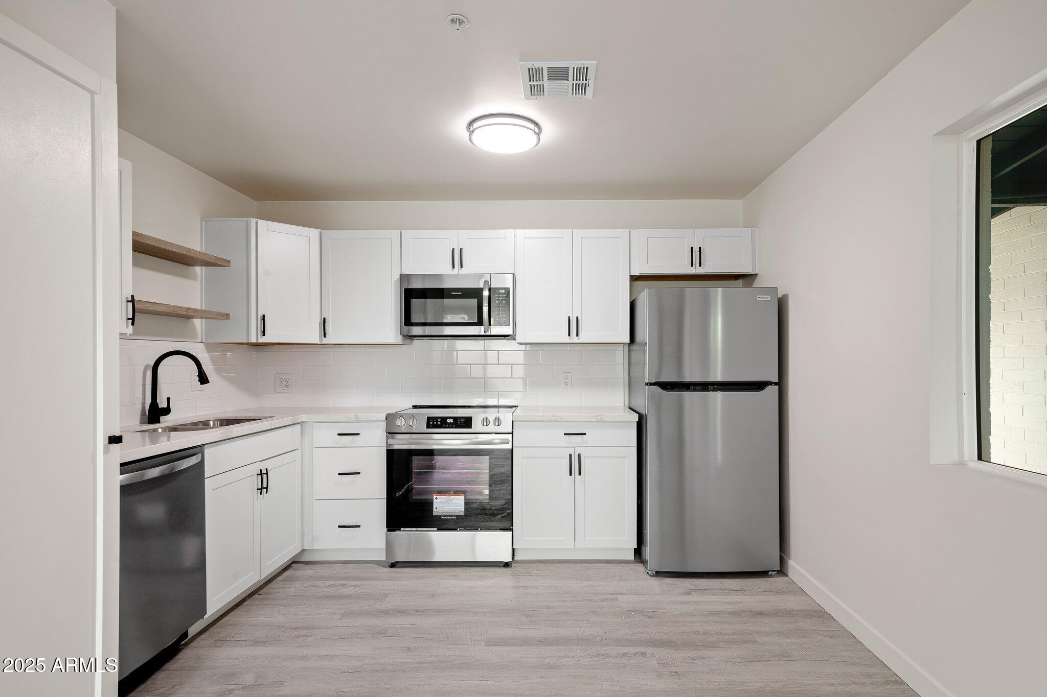3114 North 68th Street, Unit 4 Scottsdale, AZ 85251 - Photo 13 of 25 a kitchen with stainless steel appliances cabinets a sink and a refrigerator