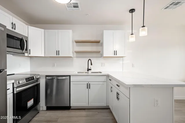 a kitchen with white cabinets stainless steel appliances and sink