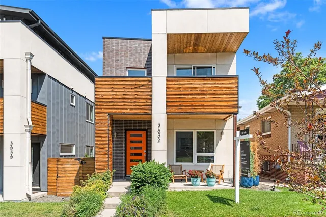 a view of a house with brick walls and a yard with plants