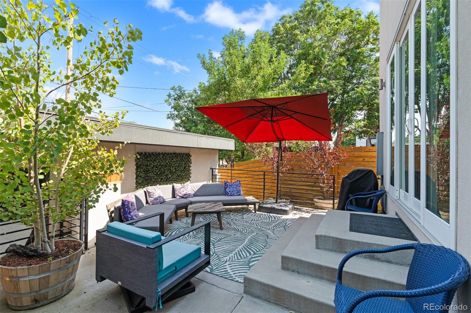 3632 North Pecos Street Denver, CO 80211 - Photo 45 of 47 a view of a patio with couches table and chairs under an umbrella with a fire pit