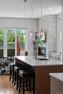 a kitchen with stainless steel appliances a sink a stove a refrigerator and white cabinets with wooden floor