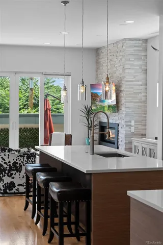 a kitchen with stainless steel appliances a sink a stove a refrigerator and white cabinets with wooden floor