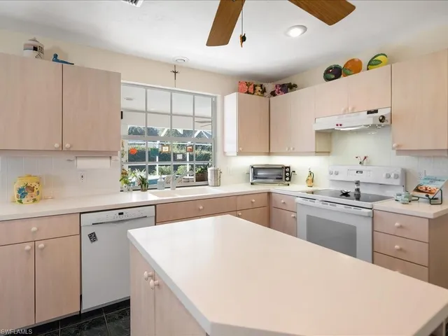 a kitchen with a sink window and cabinets