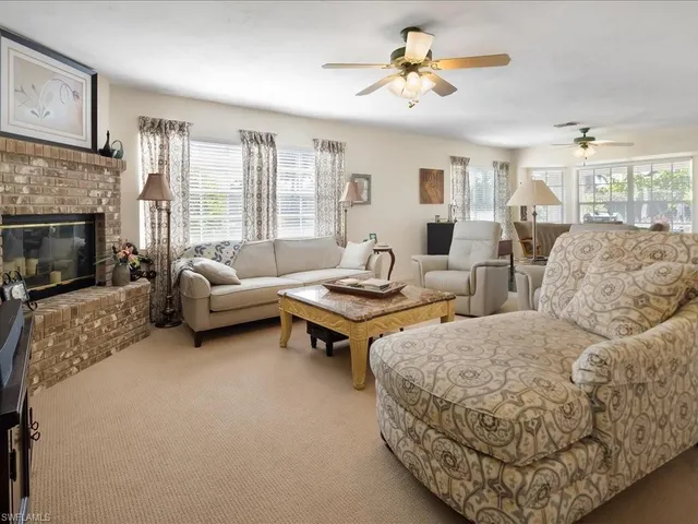 a living room with furniture ceiling fan and a fireplace