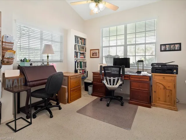 a view of a workspace with furniture and a window