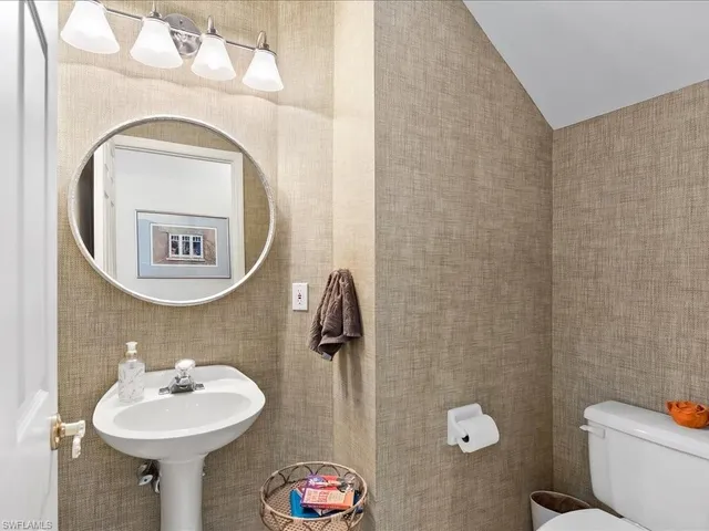 a bathroom with a sink mirror and toilet