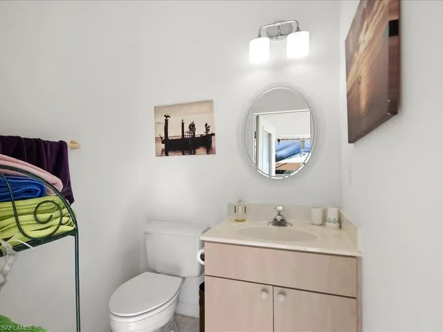 a bathroom with a toilet sink vanity and mirror