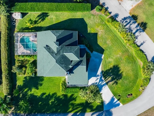 an aerial view of a house with a yard and greenery