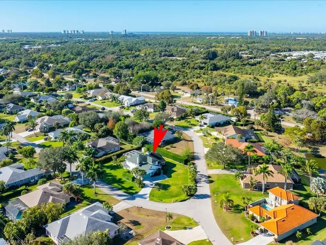 an aerial view of residential houses with outdoor space and trees