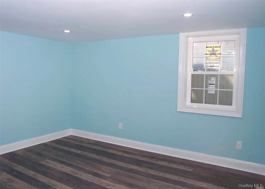15 Ivy Road Mastic Beach, NY 11951 - Photo 11 of 24 a view of empty room with window and wooden floor