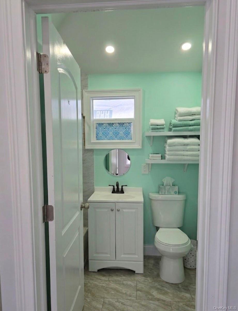 15 Ivy Road Mastic Beach, NY 11951 - Photo 17 of 24 a bathroom with a toilet sink and mirror