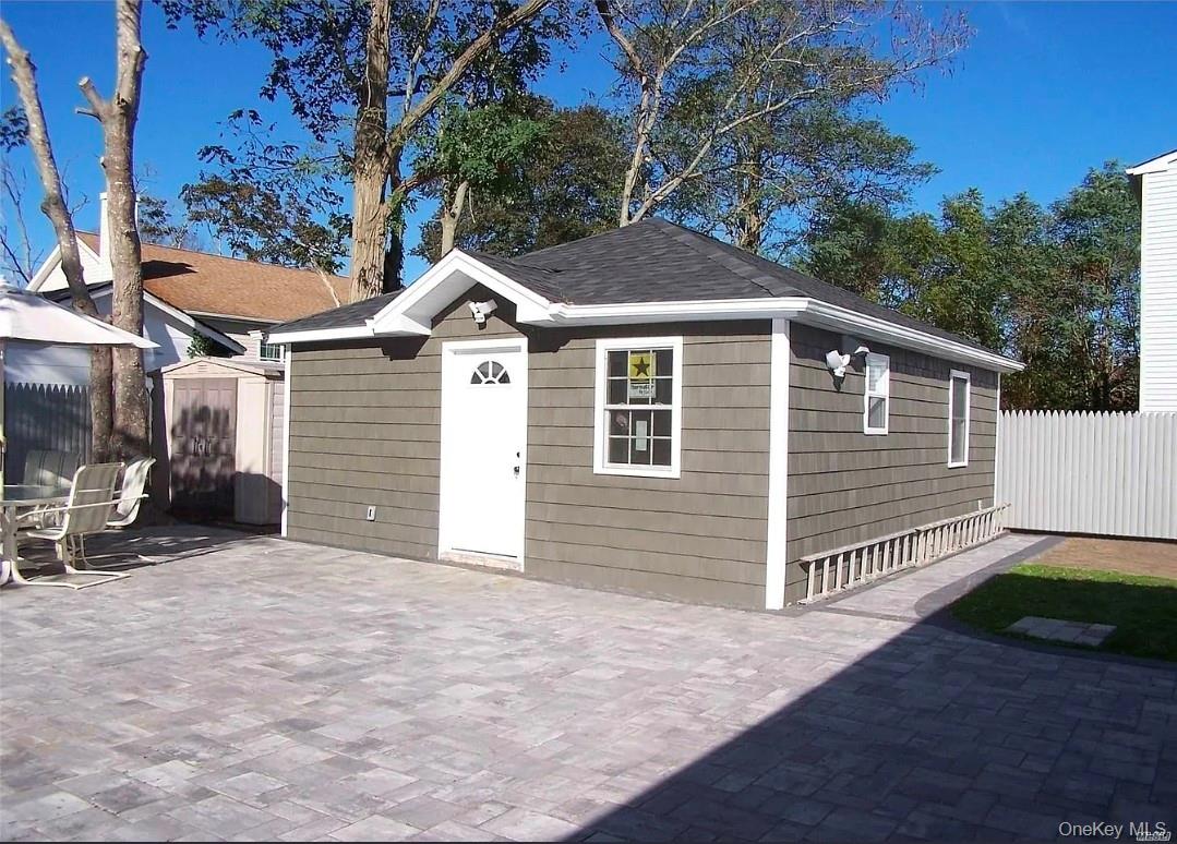 15 Ivy Road Mastic Beach, NY 11951 - Photo 19 of 24 a front view of a house with a yard and garage