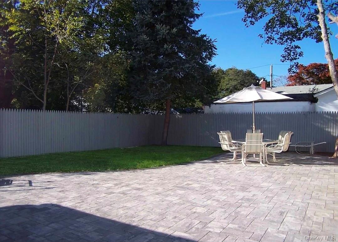 15 Ivy Road Mastic Beach, NY 11951 - Photo 20 of 24 a view of a patio with table and chairs under an umbrella