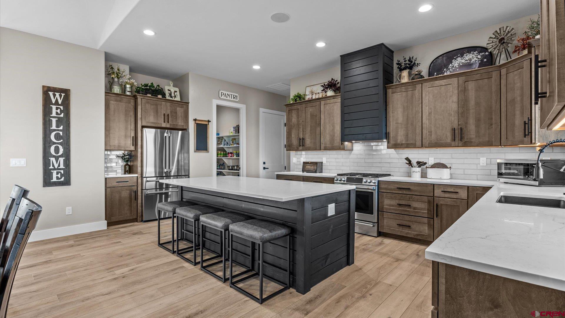 1774 Trapper Court Delta, CO 81416 - Photo 6 of 45 Chef's dream kitchen with a large quartz island, GE Café appliances, maple soft-close cabinetry, and a walk-in pantry.