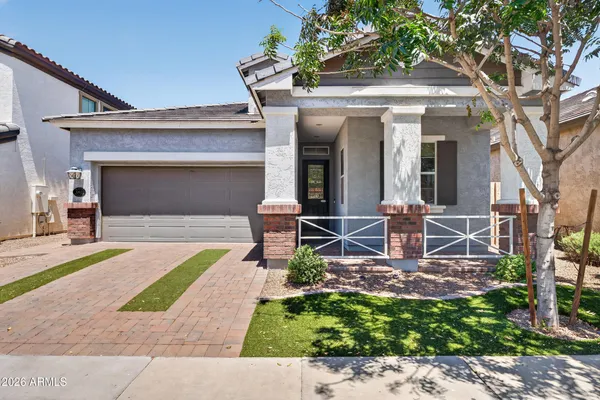 front view of a house with a bench and a rug
