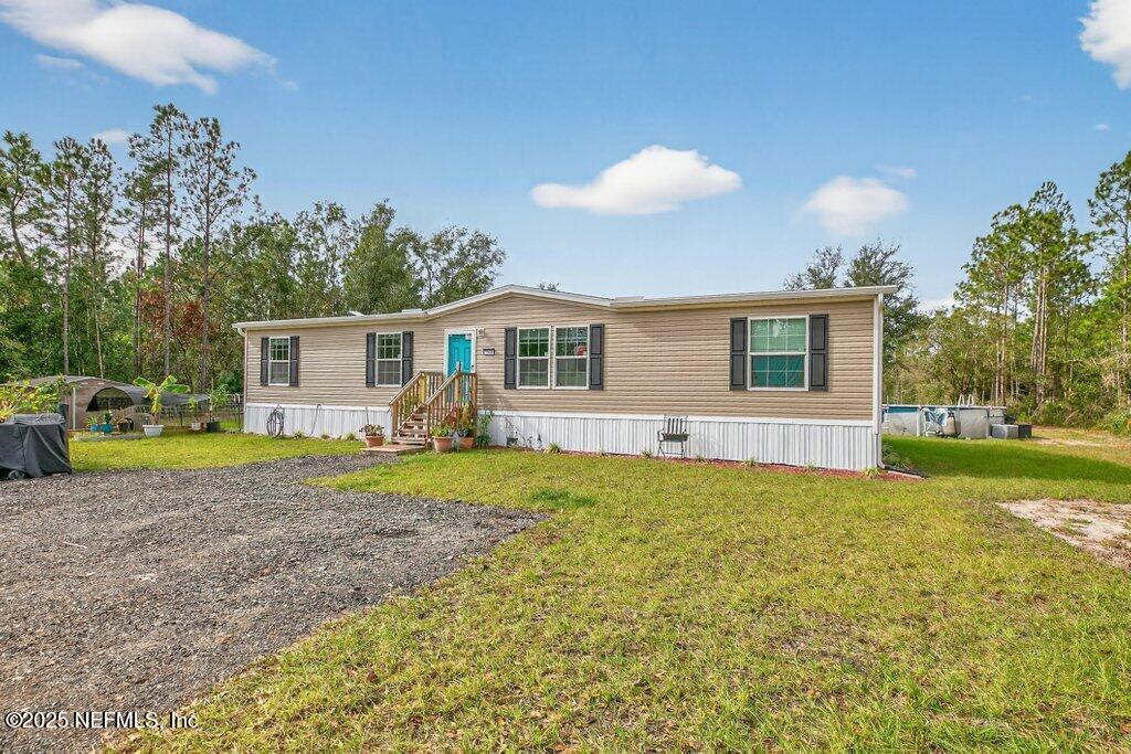 10545 Baylor Avenue Hastings, FL 32145 - Photo 2 of 17 a view of a house with a backyard and a patio