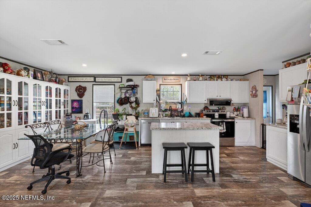 10545 Baylor Avenue Hastings, FL 32145 - Photo 6 of 17 a living room with furniture and a dining table with kitchen appliances