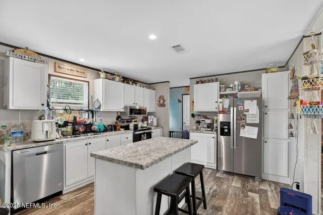 a kitchen with white cabinets and stainless steel appliances