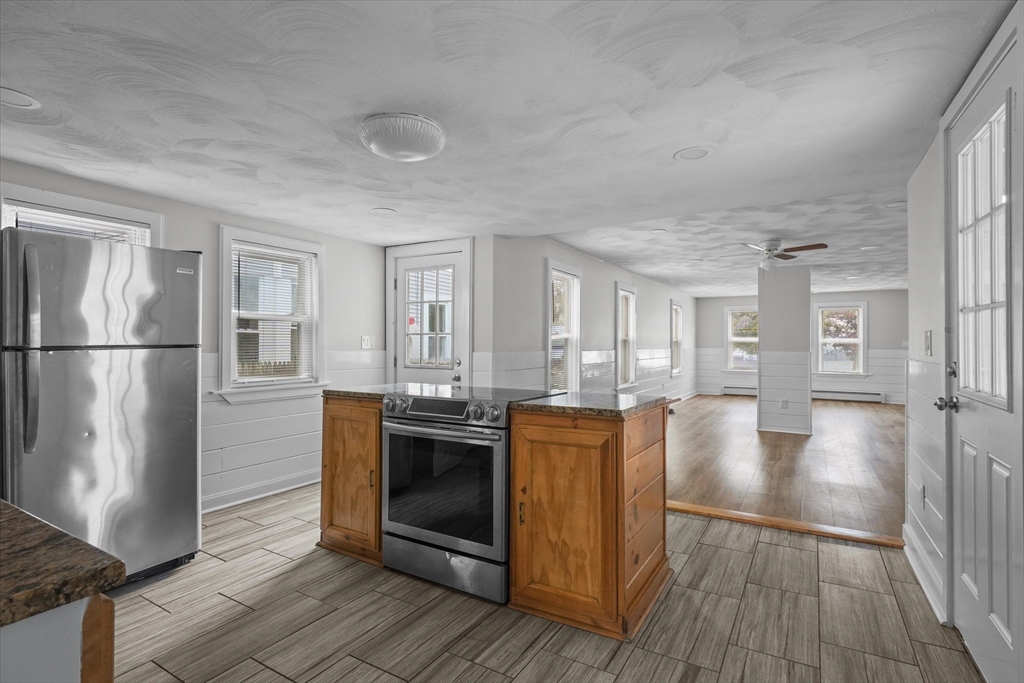 134 High Street Haverhill, MA 01832 - Photo 5 of 31 a kitchen with stainless steel appliances granite countertop a refrigerator a stove and a wooden floors