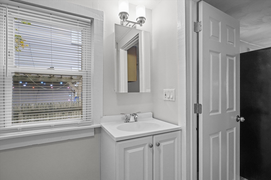134 High Street Haverhill, MA 01832 - Photo 9 of 31 a bathroom with a sink a mirror and a window