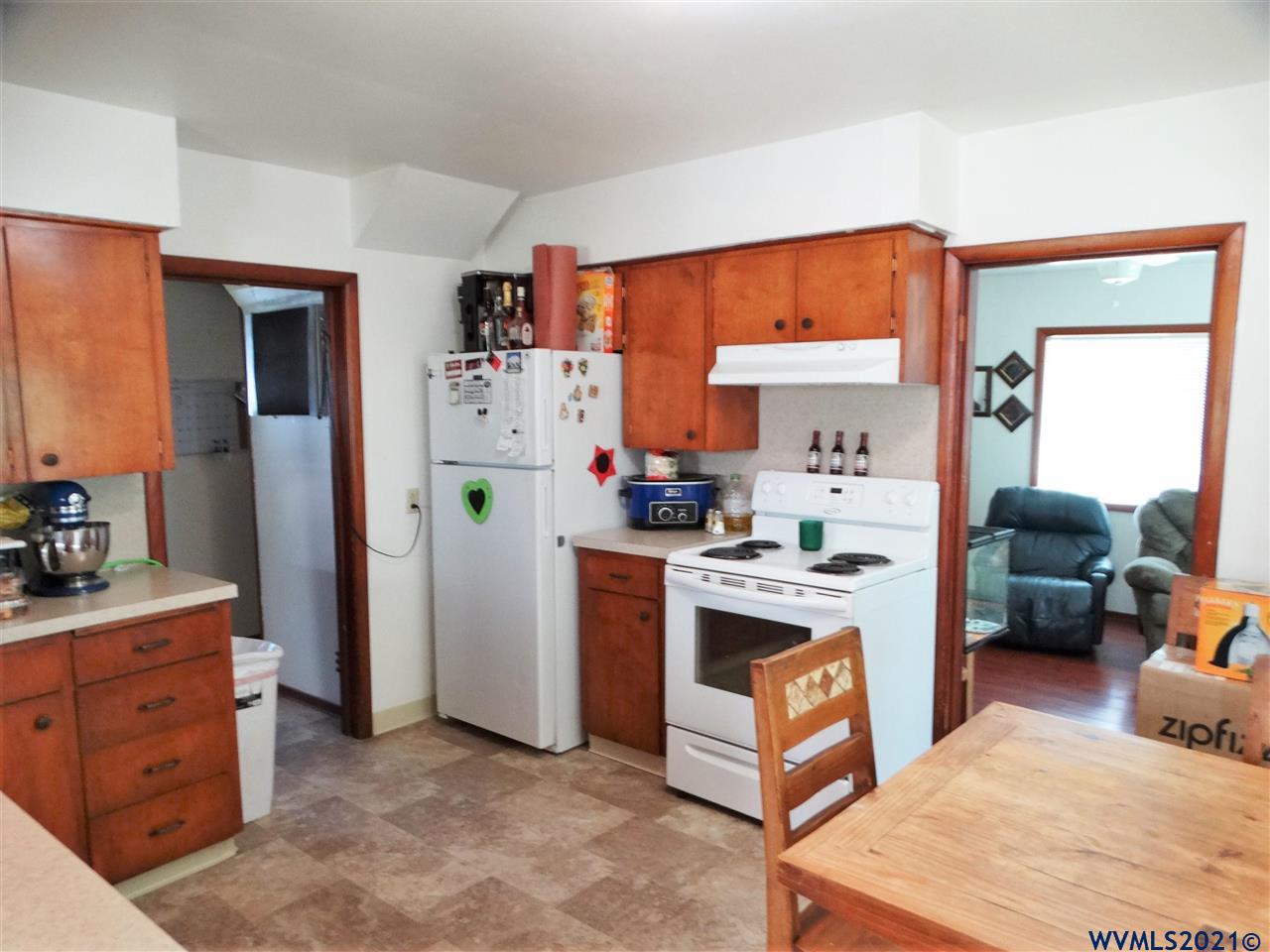 12615 Fishback Road Monmouth, OR 97361 - Photo 5 of 21 a kitchen with stainless steel appliances granite countertop a stove a refrigerator and a view of living room