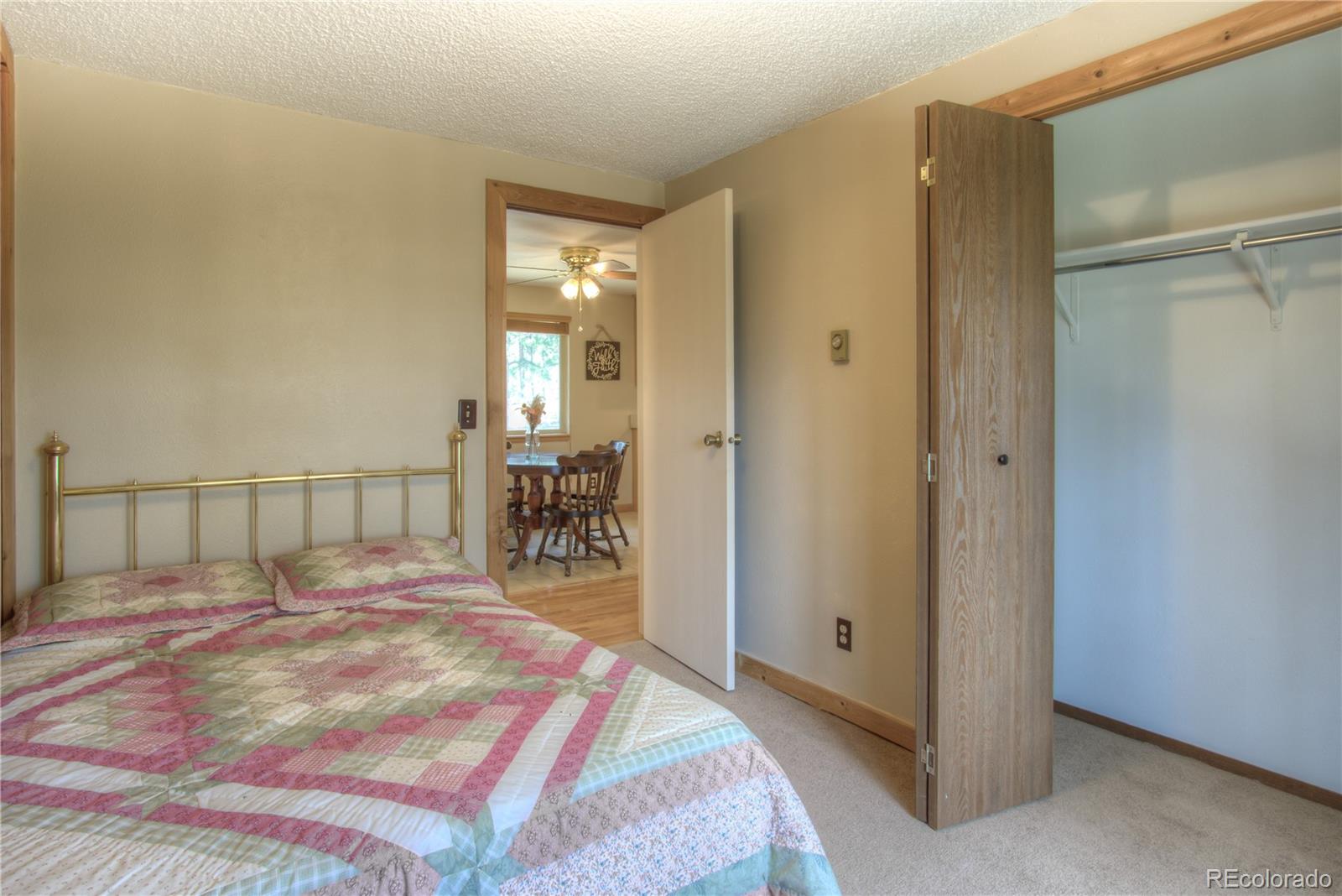 253 Raven Drive Bailey, CO 80421 - Photo 15 of 40 a bed sitting in a spacious bedroom next to a bathroom