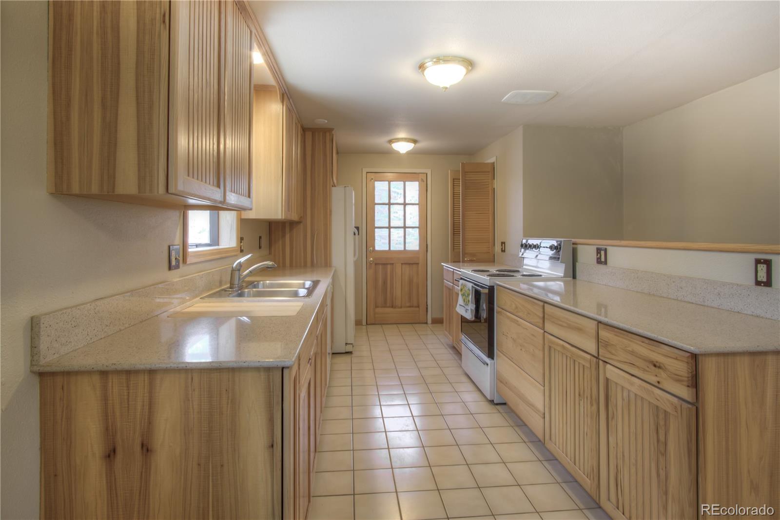 253 Raven Drive Bailey, CO 80421 - Photo 7 of 40 a kitchen with a sink stove and cabinets