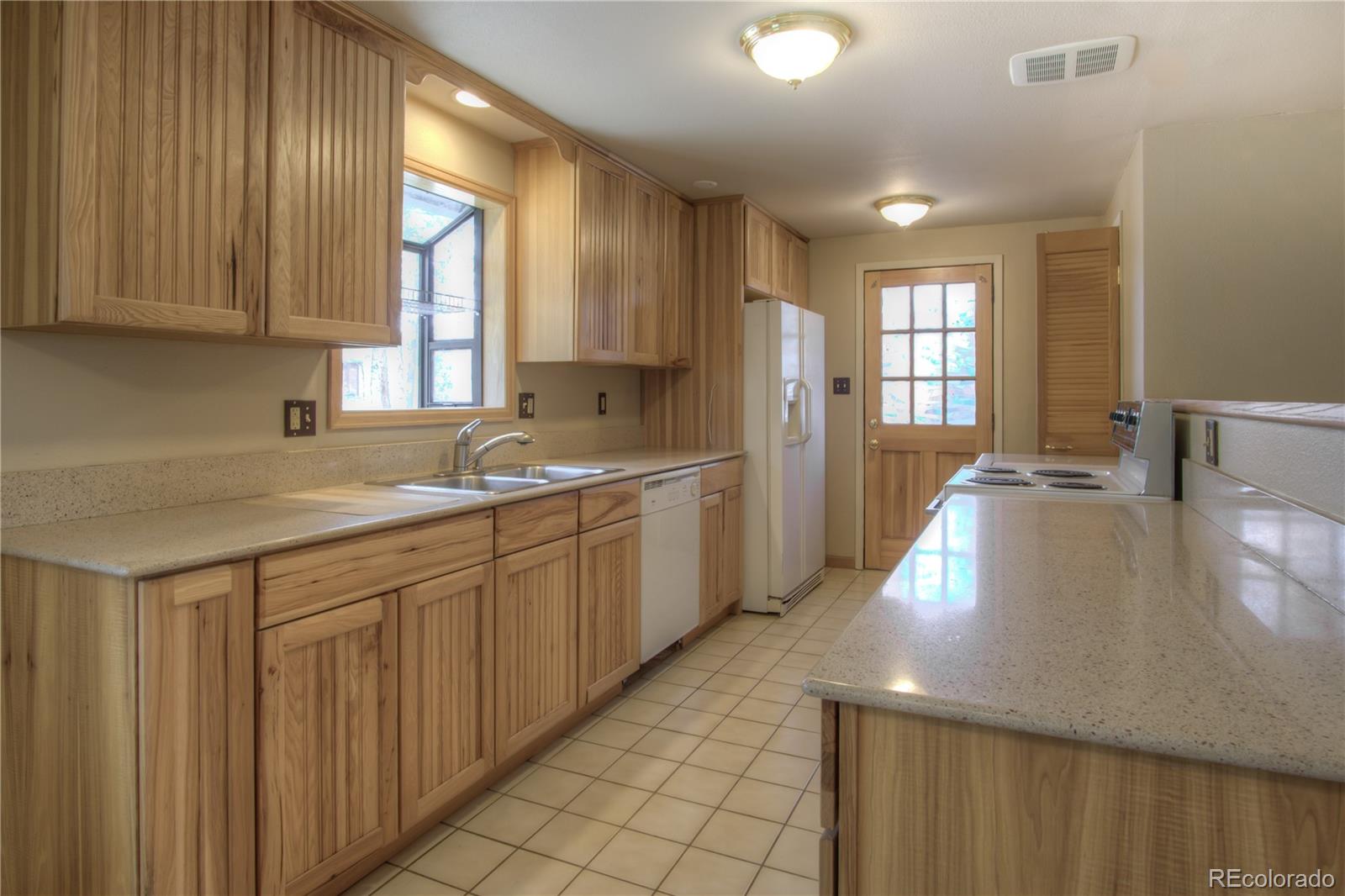 253 Raven Drive Bailey, CO 80421 - Photo 8 of 40 a kitchen with a sink cabinets and window