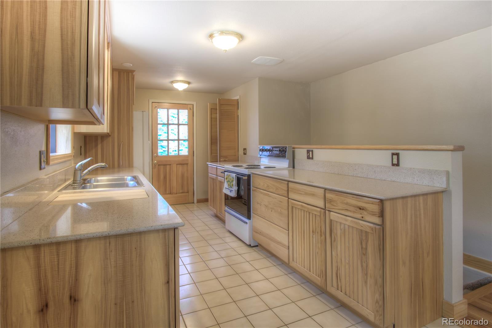 253 Raven Drive Bailey, CO 80421 - Photo 9 of 40 a kitchen with a sink stove and cabinets