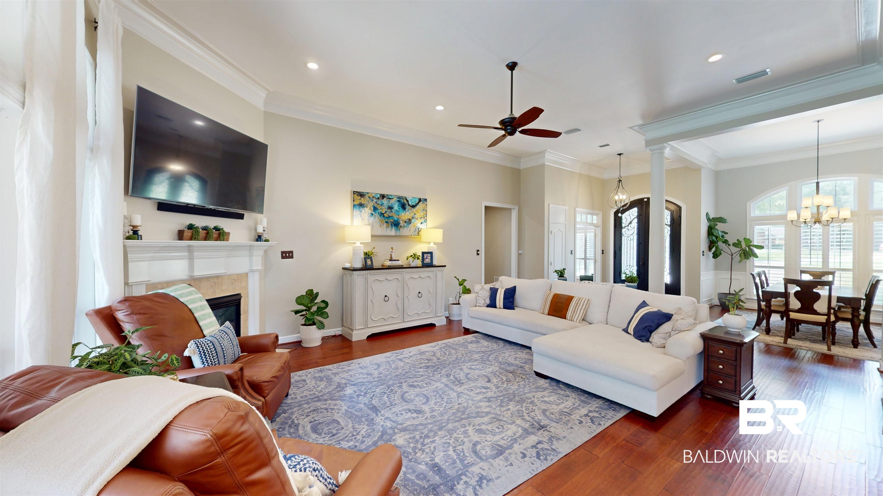 8775 Dawes Lake Road North Mobile, AL 36619 - Photo 25 of 59 Living area featuring dark wood-style flooring, ornamental molding, a glass covered fireplace, a ceiling fan, and a chandelier