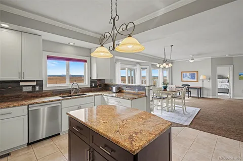 a kitchen with stainless steel appliances granite countertop a refrigerator sink stove and white cabinets