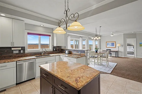 a kitchen with stainless steel appliances granite countertop a refrigerator sink stove and white cabinets