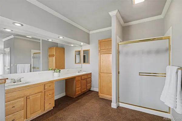 a bathroom with a double vanity sink a large mirror and a bathtub