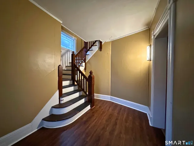 a view of entryway with stairs and wooden floor