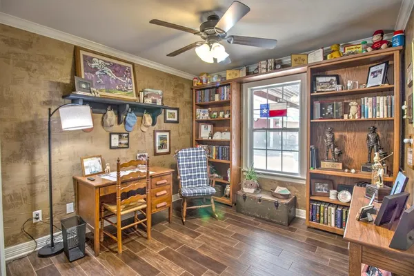 a view of a workspace with furniture and a book shelf