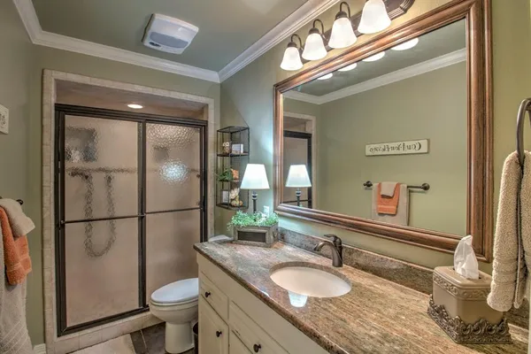 a bathroom with a granite countertop sink a toilet and a mirror